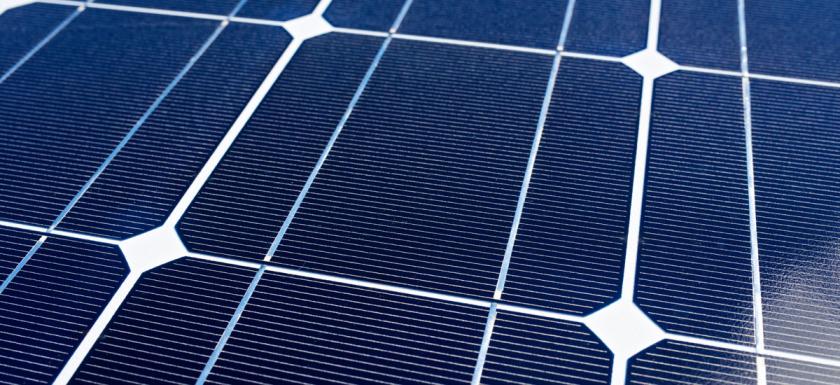 Close-up view of blue solar panel cells with white grid lines - solar photovoltaic technology